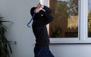 Image of home intruder about to break a window